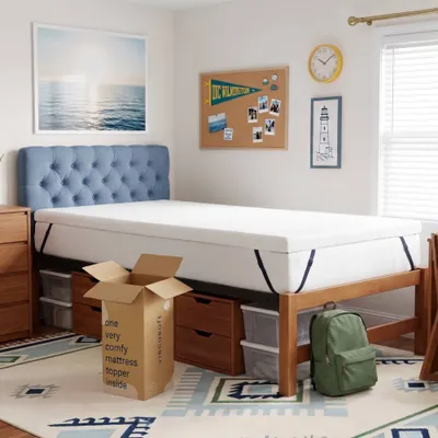 young man moving into collage putting mattress topper on his bed